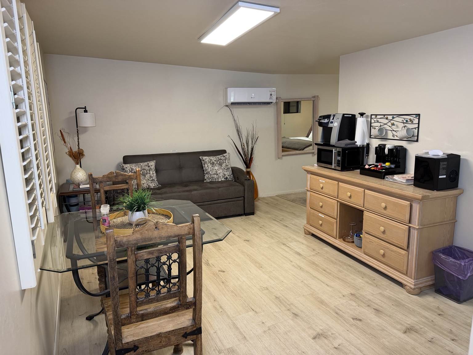Casita living and dining area with the queen sleeper sofa, table, coffee station, and refrigerator